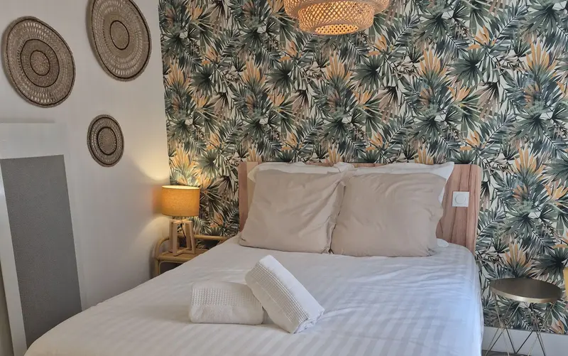 Chambre avec papier peint végétal et linge blanc