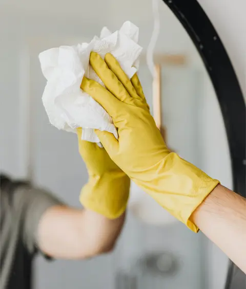 Ménage d'un miroir avec gants et chiffon